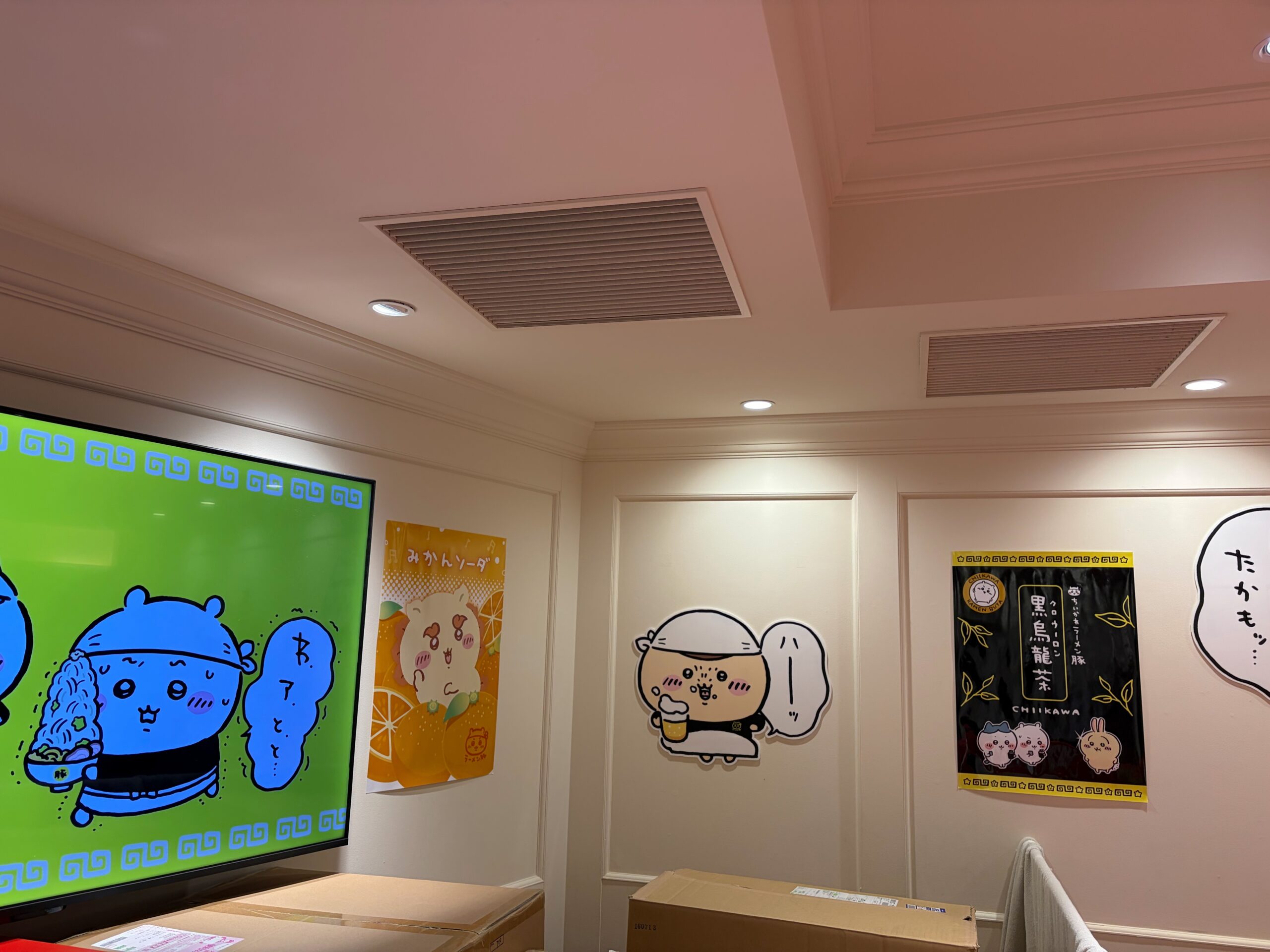 店内の壁。モニターやポスター、くりまんじゅうの「ハーッ」も